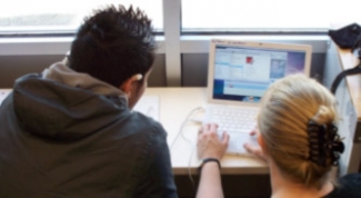 Photograph of two students at laptop.